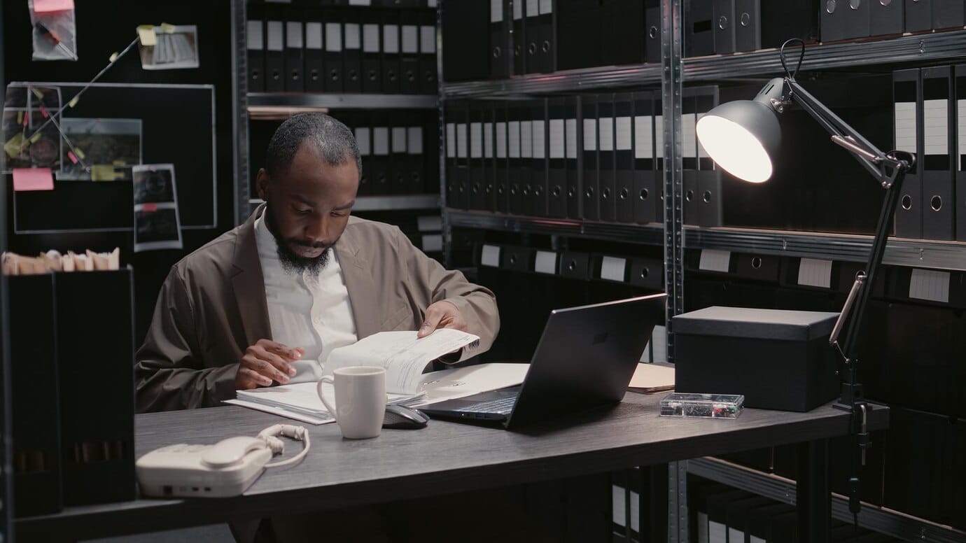 adult male going through records in his office