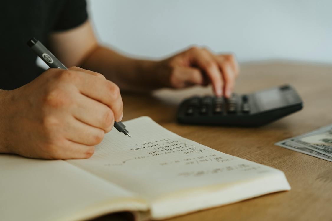 client calculating lawyer costs in a notebook