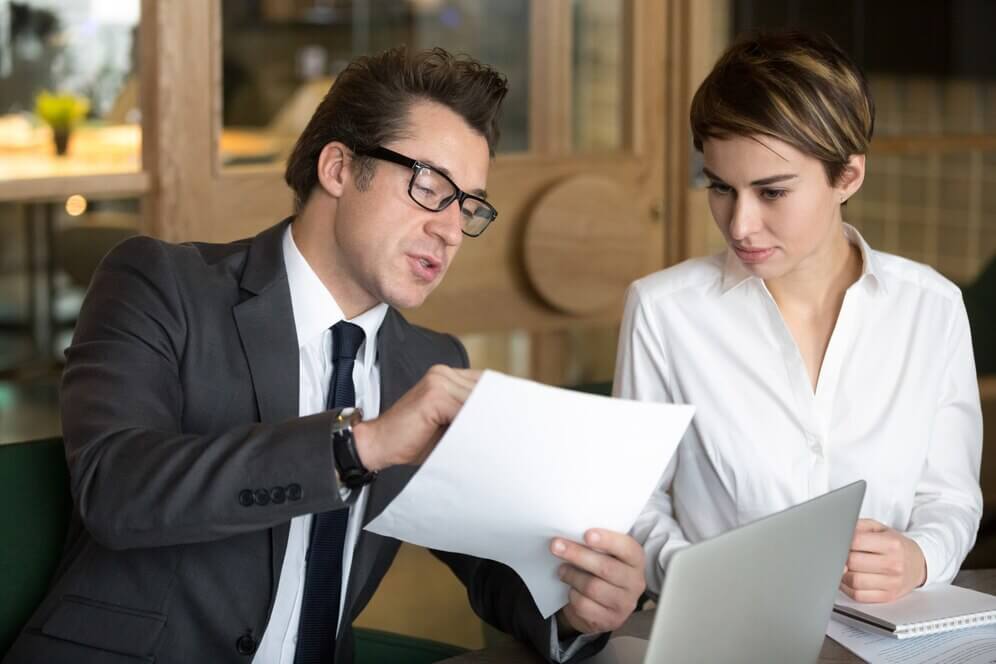 man in a suit shows documents to a woman