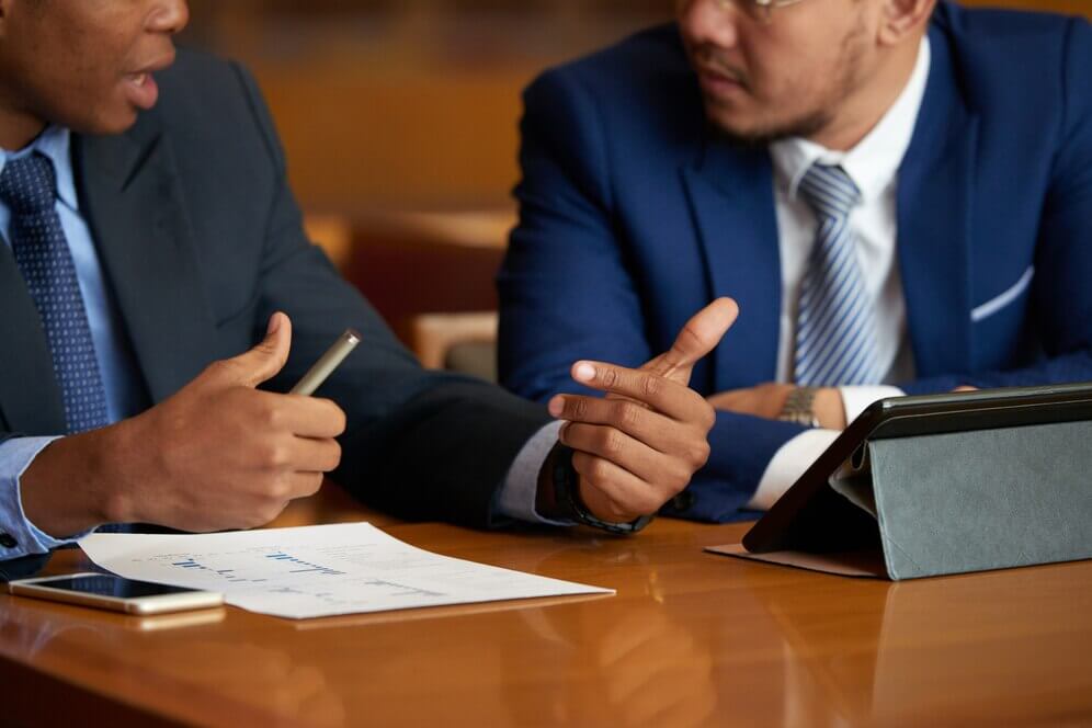 two suited men discussing on a wooden table