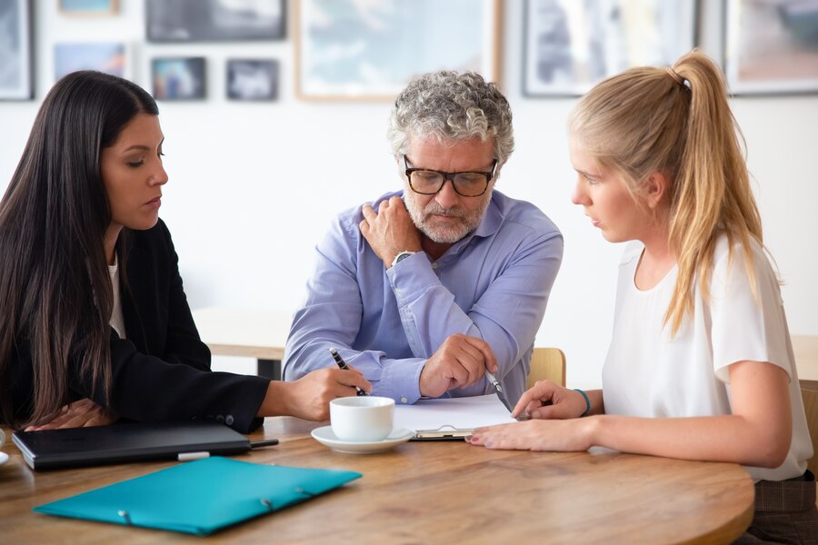 adult male in discussion with two female lawyers