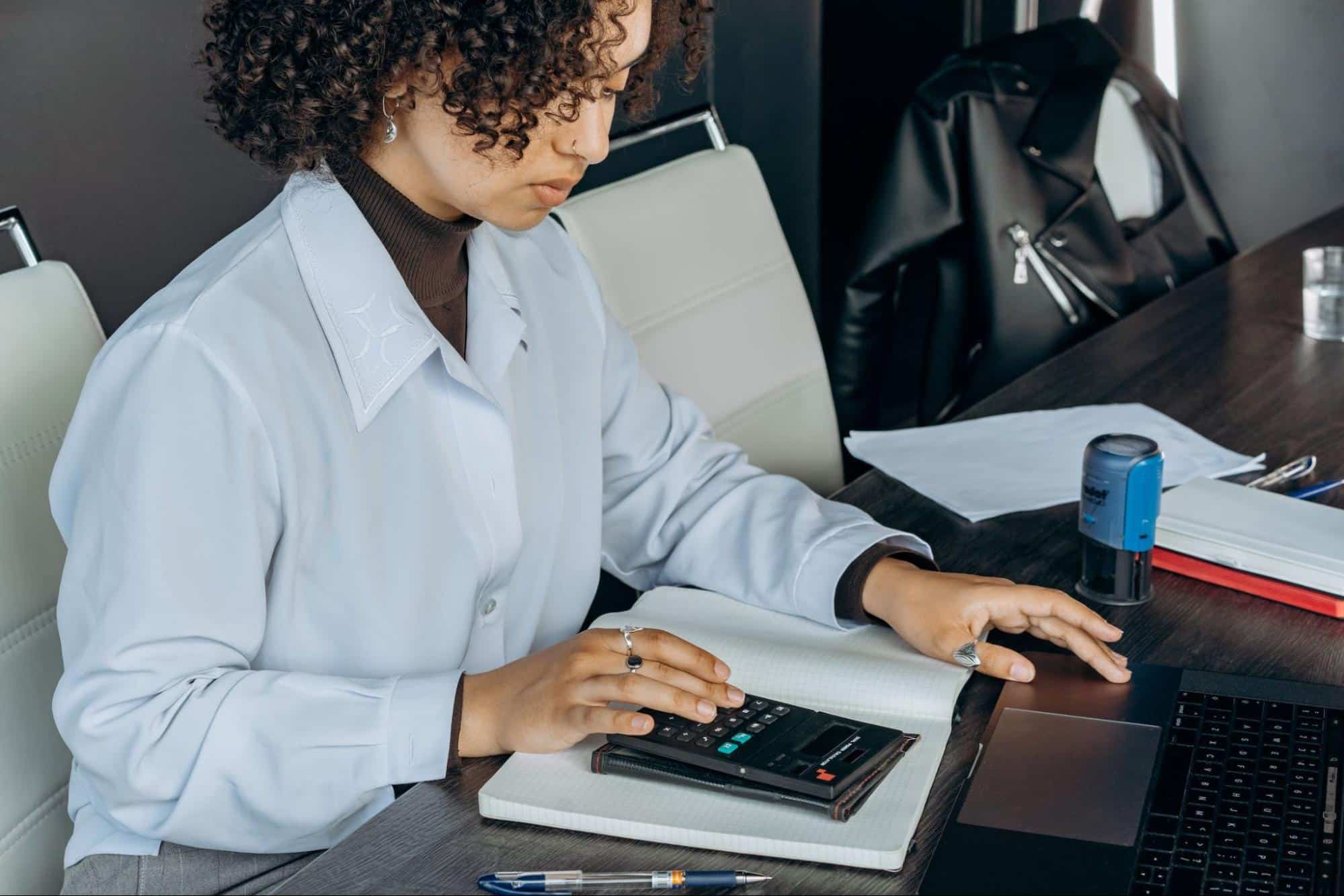 young female employee using a black calculator